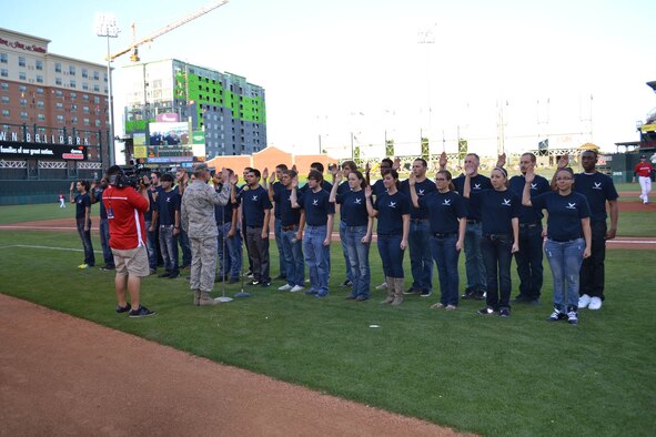 Col. Matthew C. Harris, 3rd Combat Communications Group commander, swears-in 30 Air Force recruits as one of the many different events happening at the May 11 Oklahoma City RedHawks Hometown Hero Celebration Night. Colonel Harris also threw out the ceremonial first pitch, welcomed home deployed Airmen, addressed the crowd with an inspiring speech and did a radio interview with the RedHawks radio announcer Alex Freeman. (Air Force photo by Kathy E. Paine)