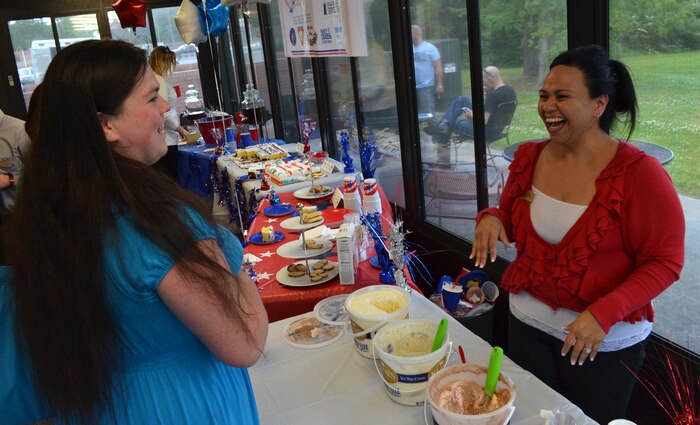 Erin Deville-Brown (right), Weapons Station Fleet and Family Support Center financial counselor and volunteer coordinator, serves ice cream and discusses family benefits with a guest at an ice cream social in recognition of Military Spouse Appreciation Day May 10, 2013, at Joint  Charleston – Weapons Station, S.C.  The event was held to thank spouses for their patience, understanding and support while informing them of services provided by FFSC. (U.S. Navy Photo/ Seaman Jason Pastrick)