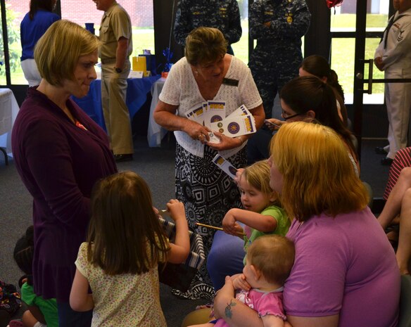 Weapons Station Fleet and Family Support Center staff and volunteers discuss family services provided to military spouses in recognition of Military Spouse Appreciation Day during an ice cream social May 10, 2013, at Joint Base Charleston – Weapons Station, S.C.  The event was held to thank spouses for their patience, understanding and support while informing them of services provided by the FFSC. (U.S. Navy Photo/Seaman Jason Pastrick)