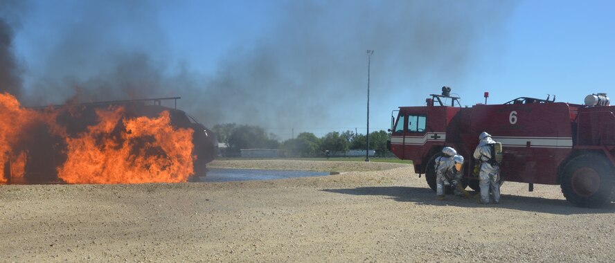 A crash fire truck circles the aircraft simulator. 433rd firefighters test its hoses as they aim at the aircraft during annual live fire training.  The fire truck can discharge gallons of water within a matter of minutes. (U.S. Air Force photo by Minnie Jones)

