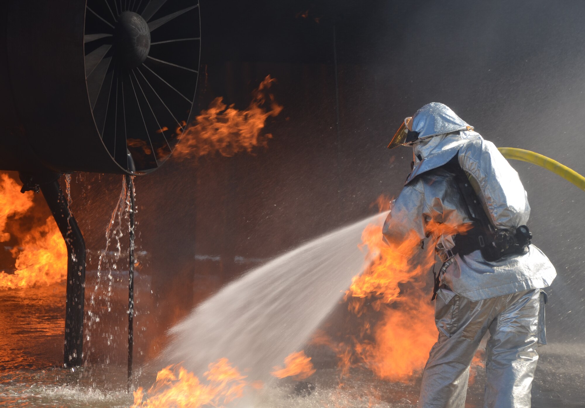 Firefighters battle fires on an aircraft simulator that is controlled from a control tower. Operators can control how much fuel is dispensed during a live-fire exercise.  (U.S. Air Force photo by Senior Master Sgt. Minnie Jones)