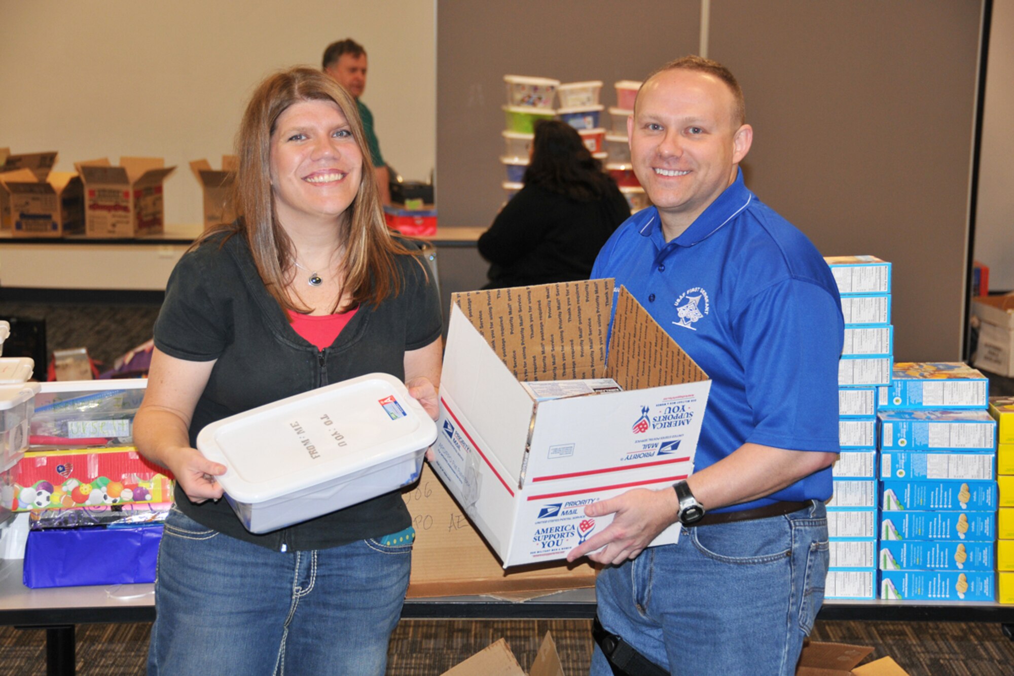 Senior Master Sgt. David F. Strickland, 80th APS first sergeant, and Kelley Janzen, key spouse, pack items into care packages for deployed Airmen with other spouses, friends and the Airmen and Family Readiness Office, during Dobbins’ Care Package Day, April 20. Over 50 Airmen from the 80th APS have deployed through February, March and April in support of operations in the middle east. (U.S. Air Force photo/Senior Airman Elizabeth Van Patten)
