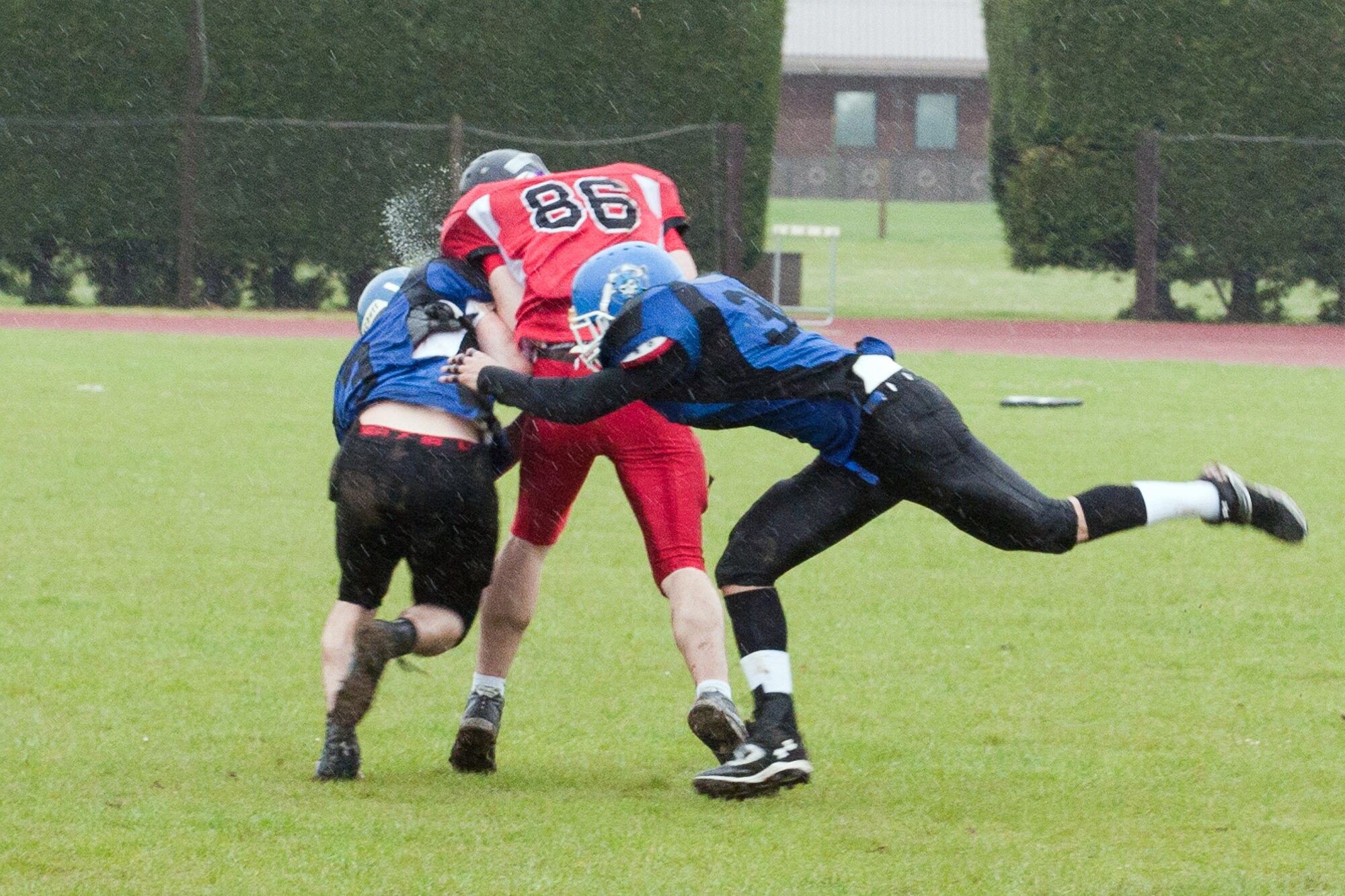 RAF ALCONBURY, United Kingdom – Alex Cushing and Albert Lamboy, Peterborough Saxons defensive backs, collide with Sam Carter, Cambridgeshire Cats wide receiver, during the second quarter of the first ever Bob "The Dog" Shaw Classic May 12 at the RAF Alconbury football field. These two teams have a history of playing each other for years and consider each other rivals. Both teams also have military personnel from RAF Alconbury, RAF Molesworth, RAF Mildenhall and RAF Lakenheath playing alongside British players. Coach Bob Shaw was a part of both teams as an offensive line coach for both the Saxons and Cats, and was the head coach for the Cats. (U.S. Air Force photo by Staff Sgt. Brian Stives)