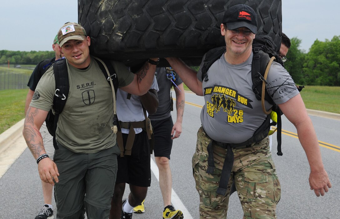 Participants of the 11th Security Forces Group, National Police Week Ruck March, carry a giant tire around Perimeter road on May 15, 2013 at Joint Base Andrews, Md. Military service members and local policemen took part in the approximately nine mile event. (U.S. Air Force photo/Airman 1st Class Nesha Humes)
