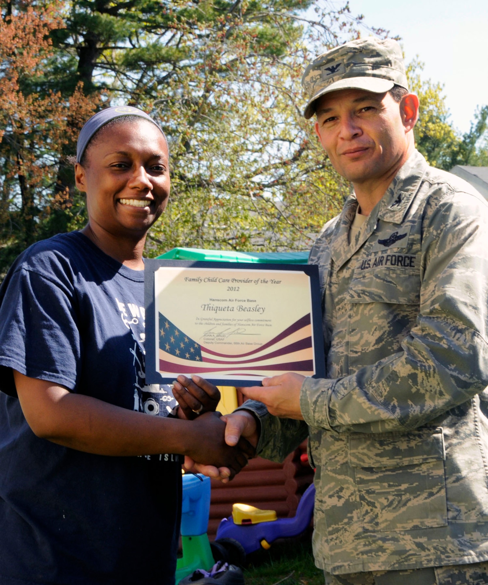 HANSCOM AIR FORCE BASE, Mass. -- Col. Juan Gaud, 66th Air Base Group deputy commander, presents Thiqueta Beasley a certificate recognizing her as the 2012 Family Childcare Provider of the Year May 10. Although relatively new to child care, Beasley is credited for her hard work and dedication to the children she cares for. (U.S. Air Force photo by Linda LaBonte Britt)