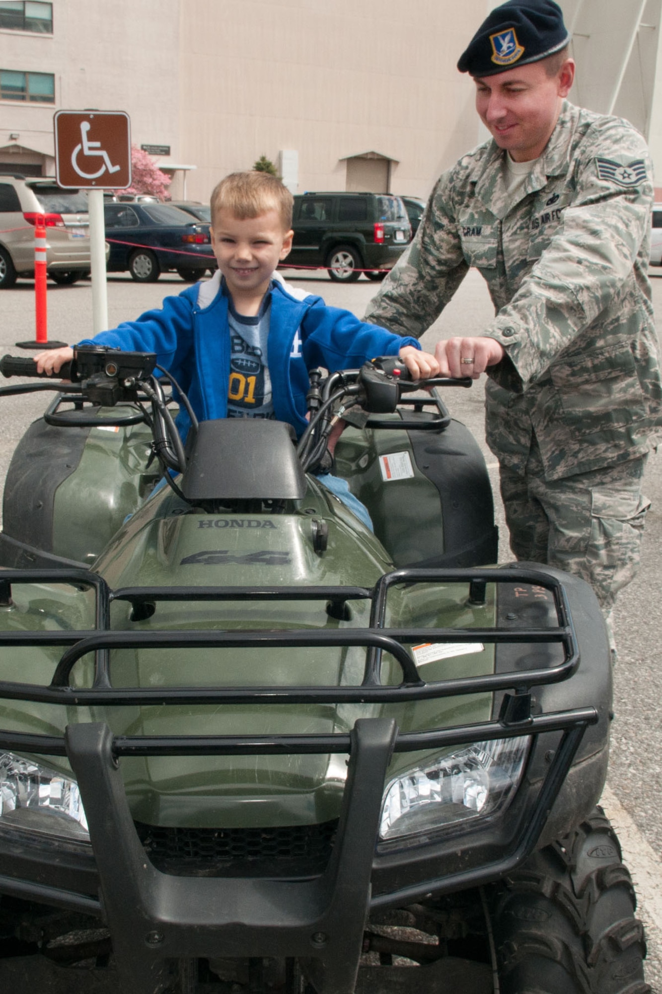 HANSCOM AIR FORCE BASE, Mass. – Staff Sgt. Paul Cram, Jr., 66th Security Forces Squadron, Reports and Analysis NCO in charge, shows Tyler Pope, age 4, an all-terrain vehicle as part of an equipment display outside the Base Exchange May 14 during Police Week. The 66th Security Forces Squadron hosted several events throughout the week including a K-9 and equipment demonstration, 5K fun run, POW/MIA ceremony and a barbecue. (U.S. Air Force photo by Rick Berry)