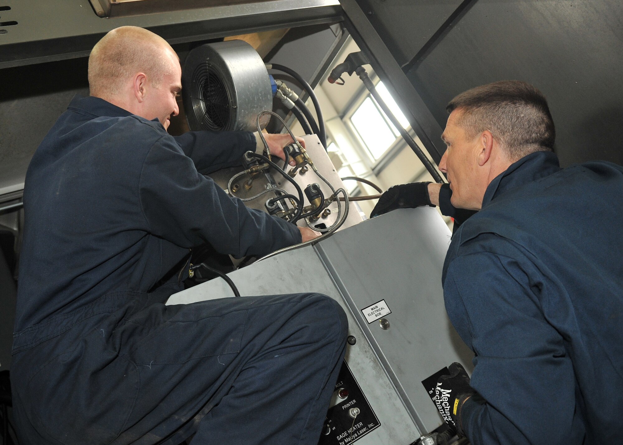 From left, Senior Airman Kane Goligoski, 100th Logistics Readines Squadron vehicle and vehicular equipment mechanic from Columbus, Ga., and Chief Master Sgt. Tracy Jones, 100th Air Refueling Wing command chief, inspect a global deicer’s fuel burner May 15, 2013, on RAF Mildenhall, England. In addition to the global deicer, Airmen assigned to the 100th LRS Special Purpose shop work on vehicles such as aircraft loaders, tow tractors and dump trucks. (U.S. Air Force photo by Senior Airman Jerilyn Quintanilla/Released)