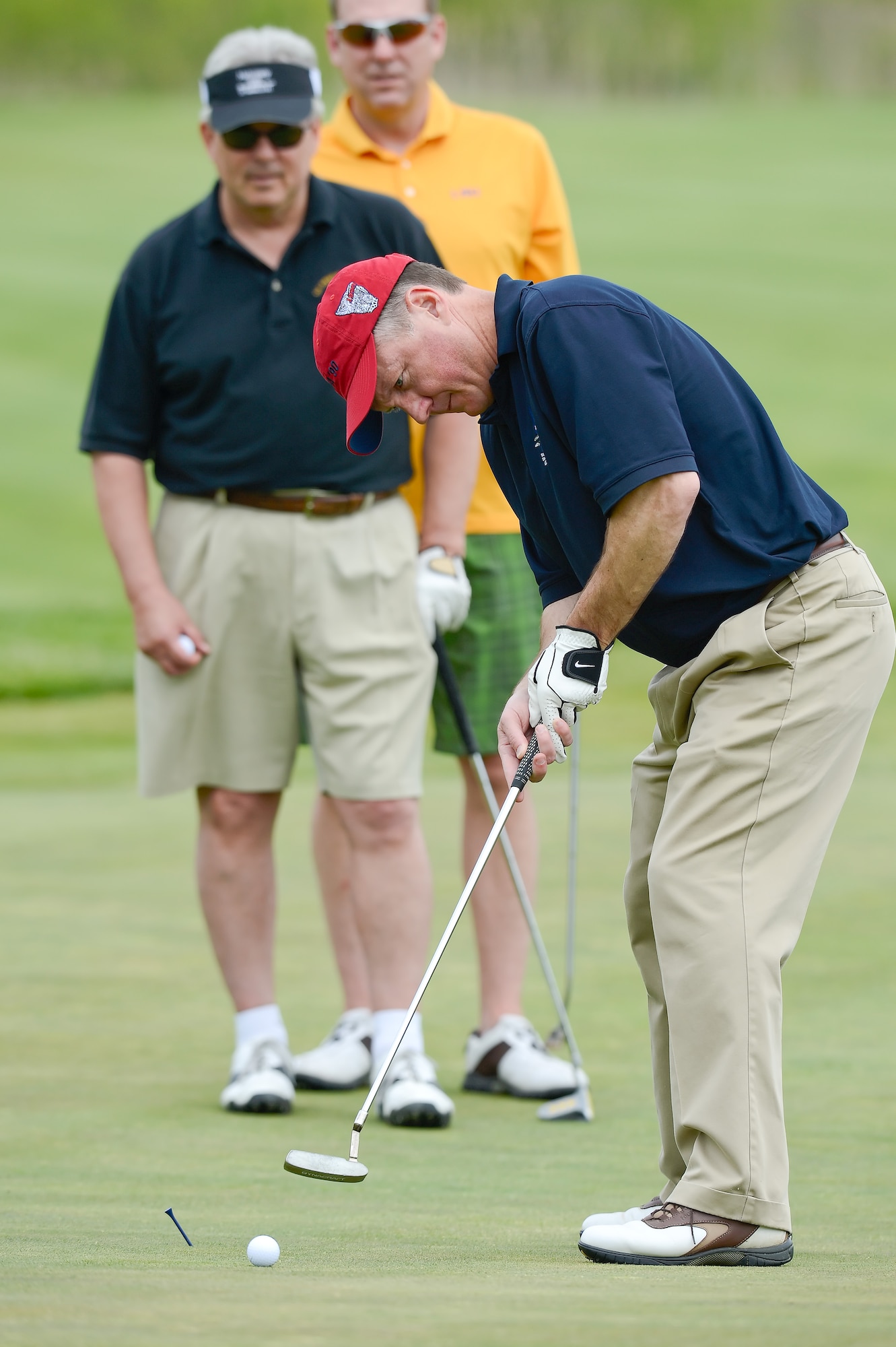 Colonel Cal Mercer, 436th Airlift Wing Vice Commander, putts a golf ball toward the hole on the 11th green at Jonathon's Landing Golf Course, near Dover Air Force Base, Del. while a local civic leader, Mr. John Still, President of the military affairs committee, and the 436th AW Director of Staff, Lieutenant Colonel Jon Fullerton look on May 15th, 2013. Key military leaders from Dover AFB were paired with local civic and business leaders for the Bluesuiters Golf Tournament as part of Dover's robust community outreach program. (U.S. Air Force photo/Greg L. Davis)