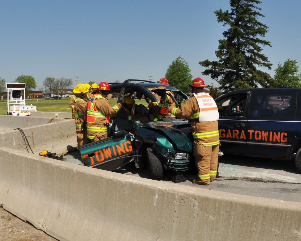 Fire and emergency personnel from the 914th Airlift Wing remove the roof of a vehicle in order to aid passengers during a crash demonstration for the Traffic Safety Program at Niagara Falls Air Reserve Station, May 15, 2013. (U.S. Air Force photo by Staff Sgt Stephanie Clark) 