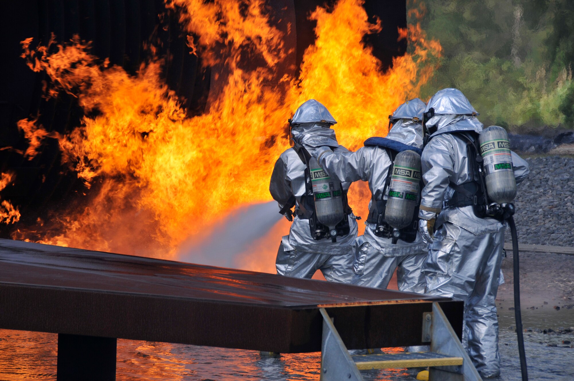 Members of Homestead Air Reserve Base, Fla.’s Fire Department extinguish a fire outside the burning fuselage of a mock aircraft during aircraft live fire training at Homestead ARB May 15. Fires can heat up the mock aircraft to approximately 1,200 degrees. The aircraft live fire training consists of responding to the fire, setting up on the aircraft, deploying hose lines, and attacking and extinguishing the fire. (U.S. Air Force photo/Senior Airman Nicholas Caceres)
