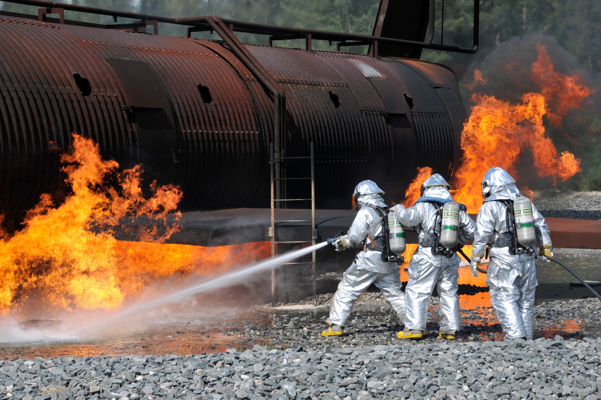 Members of Homestead Air Reserve Base, Fla.’s Fire Department extinguish a fire outside the burning fuselage of a mock aircraft during aircraft live fire training at Homestead ARB May 15. Fires can heat up the mock aircraft to approximately 1,200 degrees. The aircraft live fire training consists of responding to the fire, setting up on the aircraft, deploying hose lines, and attacking and extinguishing the fire. (U.S. Air Force photo/Senior Airman Nicholas Caceres)