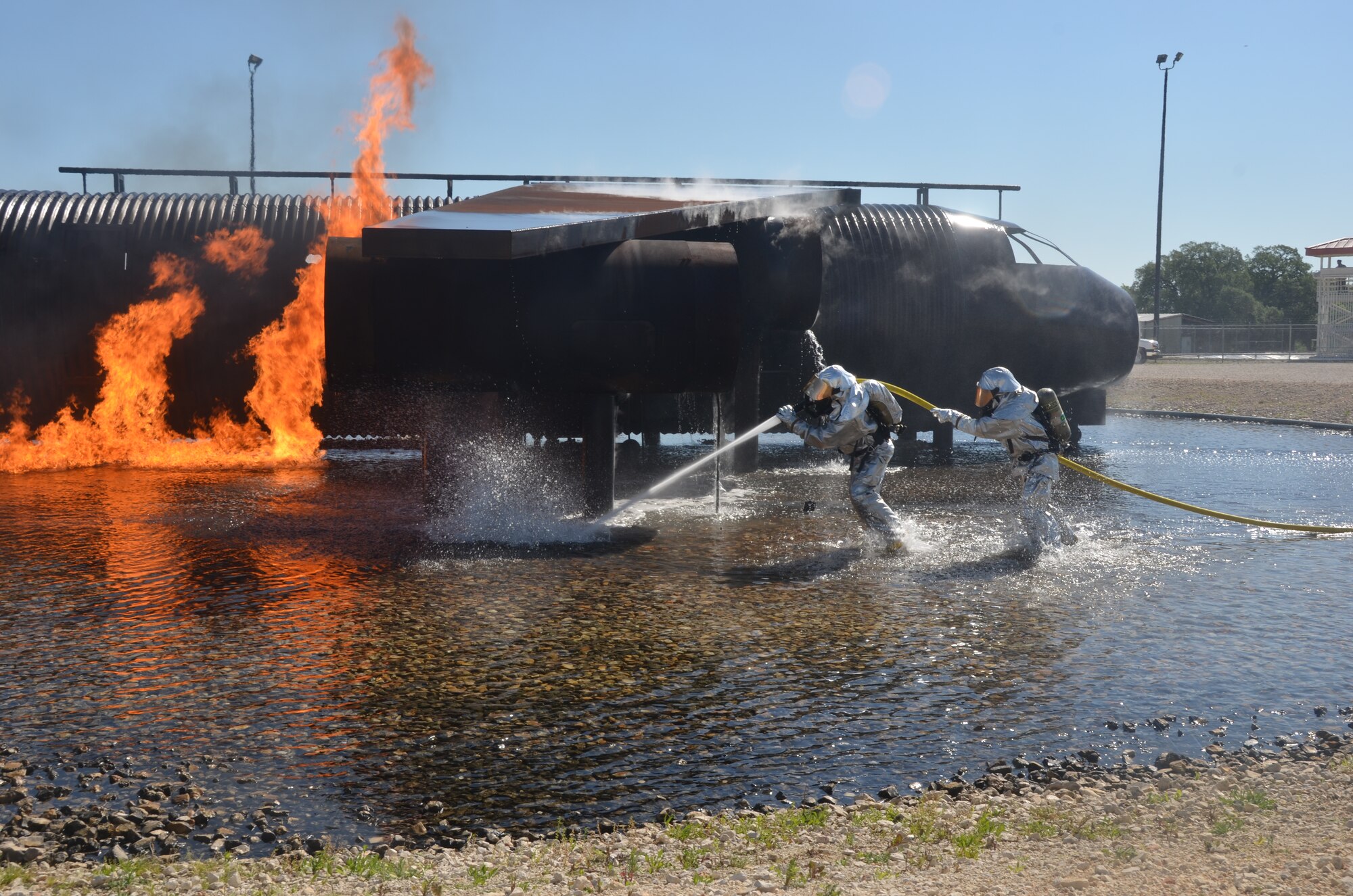 Two 433rd firefighters run toward an aircraft fuselage simulator during a training exercise May 3 at Joint Base San Antonio-Randolph, Texas.  (U.S. Air Force photo by Minnie Jones)