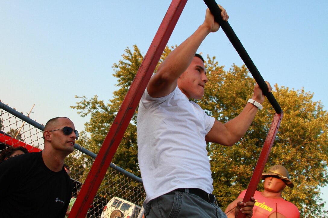 Sgt. Ronny Muller, a recruiter with Recruiting Substation Lindenhurst, counts a student's pullups at an Enhanced Area Canvassing event at Brentwood High School Oct. 5, 2012. For a pullup to count, the arms must completely lock out in the down position and the chin must be raised above the bar in the up position.