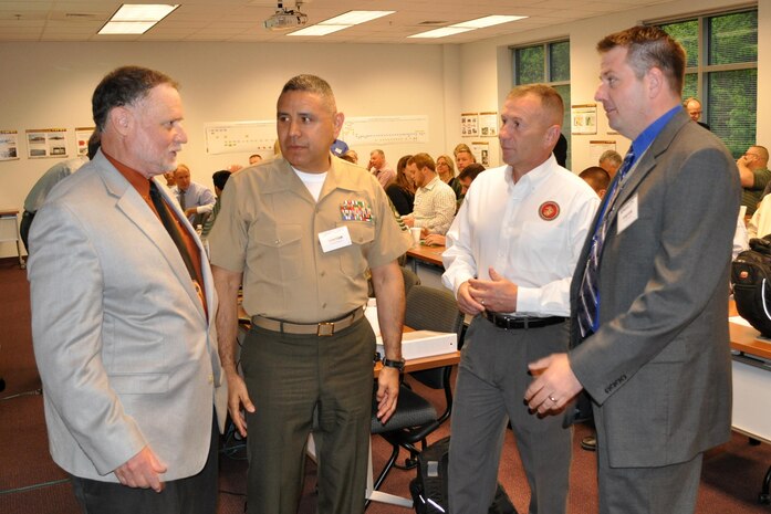 From left, Daniel Dunmire, director of the Department of Defense Corrosion Office; Master Gunnery Sgt. Antonio Zambrano, maintenance management chief with Installations and Logistics; Bernard Friend, Corrosion Prevention and Control program operations and sustainment; and Matthew Koch, CPAC program manager, talk May 7 prior to the start of the CPAC Working Group. 