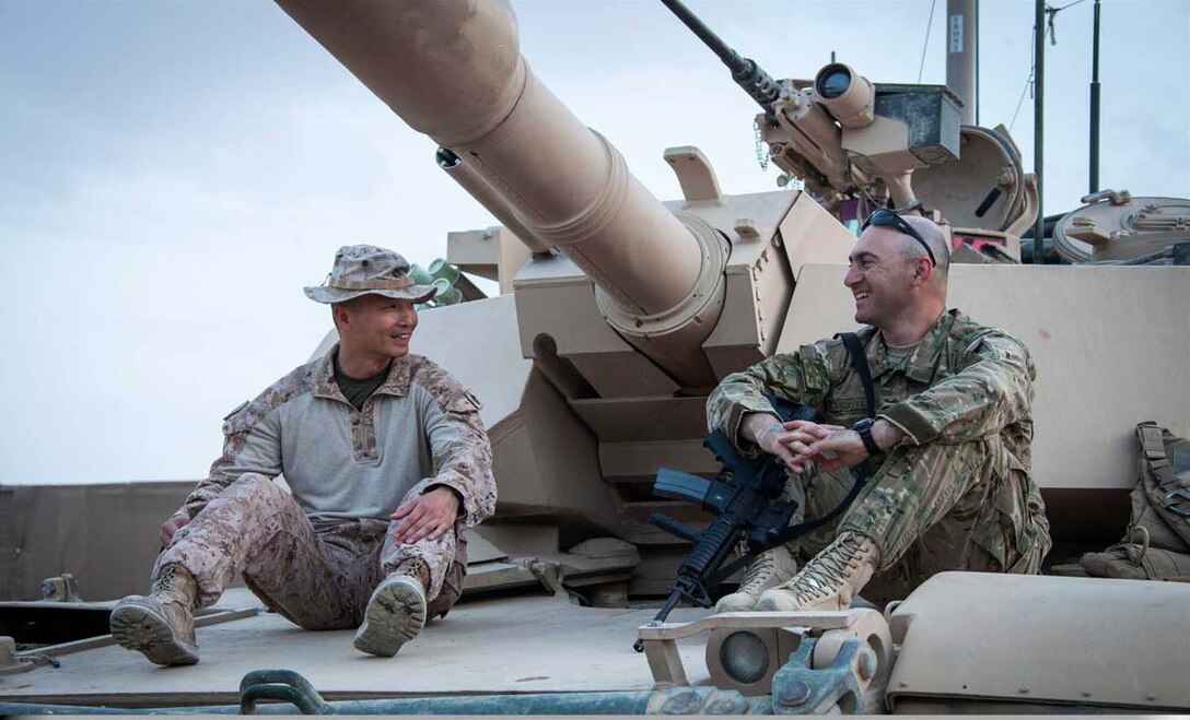 U.S. Marine Corps Master Sgt. Robert Oak, left, Civil Affairs operations chief, Headquarters Company, Regimental Combat Team 7, and Georgian Army Capt. Mikheil Mazmishvili, tour a M1A1 Abrams tank on forward operating base Shir Ghazay, Helmand province, Afghanistan, April 25, 2013.