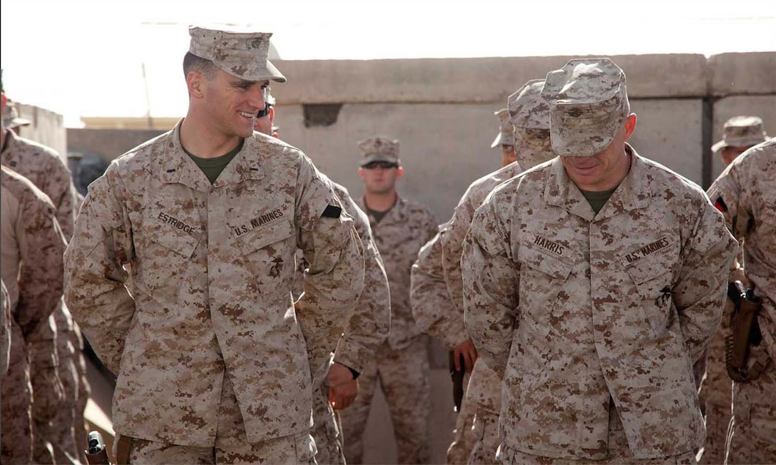 U.S. Marine Corps 1st Lt. Peter Estridge and Maj. Paul Harris, both assigned to Headquarters Company, Regimental Combat Team 7 share a moment of levity while waiting in formation on Camp Leatherneck, Helmand province, Afghanistan, May 1, 2013.