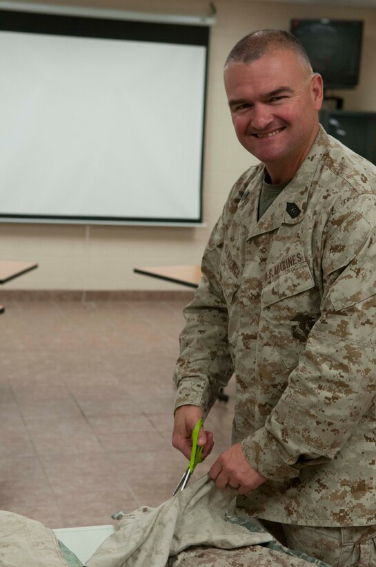 Master Sgt. Shaun Lawrence, a Uniform Victim Advocate with Marine Fighter Attack Squadron-121, Marine Corps Air Station Yuma, Ariz., and a native of Ulysses, Pa., cuts camouflage utilities apart to make into quilts and wall hangings, May 14. The "cammies" were donated from Marines during the "Take a Stand" motorcycle ride, April 30, in support of Sexual Assault Awareness Month. Marines and their spouses volunteer their time with Yuma community members to make quilts and wall tapestry's in support of Amberly's Place, a shelter that helps victims of domestic violence, child abuse and sexual assault.