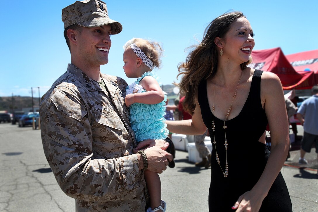 Petty Officer 3rd Class Samuel Guill, a corpsman with Combat Logistics Battalion 15, 1st Marine Logistics Group, holds his daughter and prepares to head home during CLB-15’s homecoming aboard Camp Pendleton, Calif., May 13, 2013. Several Marines and sailors returned from an eight-month deployment with the 15th Marine Expeditionary Unit. (U.S. Marine Corps photo by Cpl. Laura Gauna/Released)