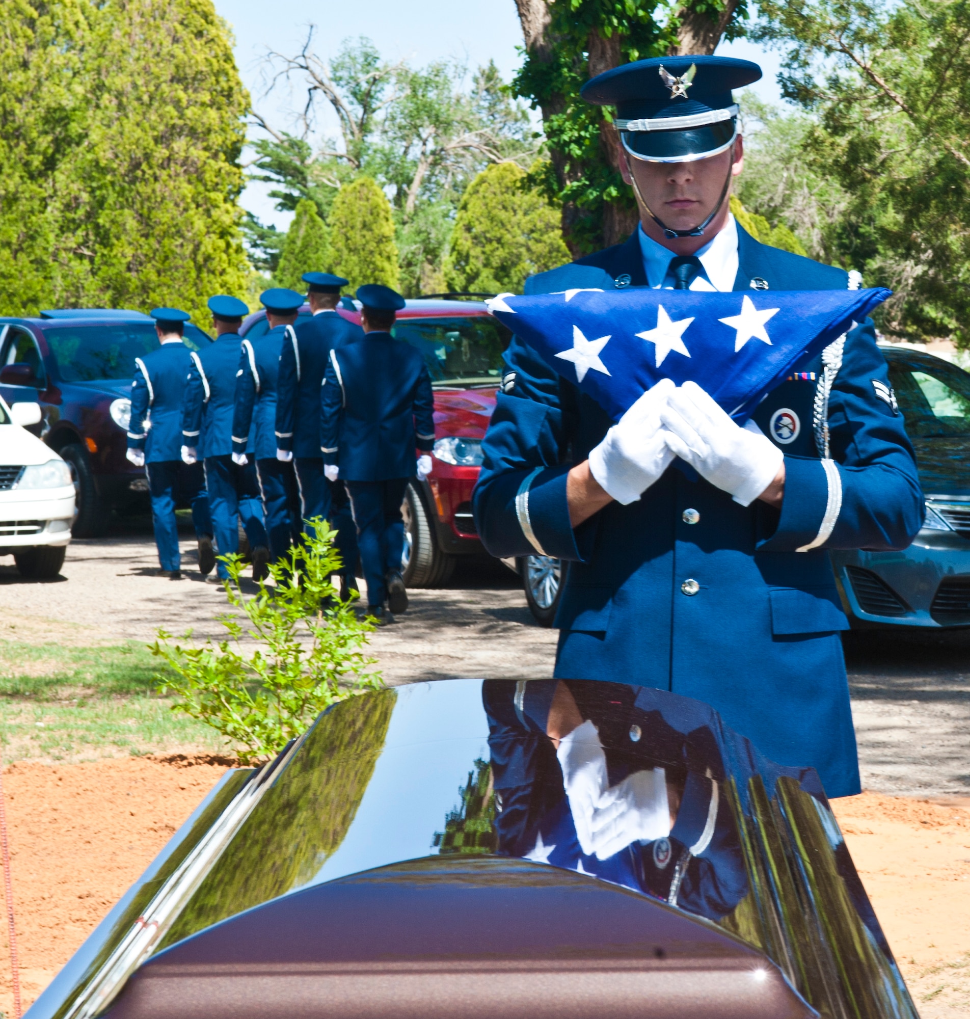 U.S. Air Force Airman 1st Class Nick Ranck, 16th Aircraft Maintenance Unit, holds the flag as he waits for taps to play during a funeral for Johnny D. Morgan in Portales, N.M., May 16th, 2013. Morgan, a combat medic, served in World War II and received a Bronze Star for his service.

