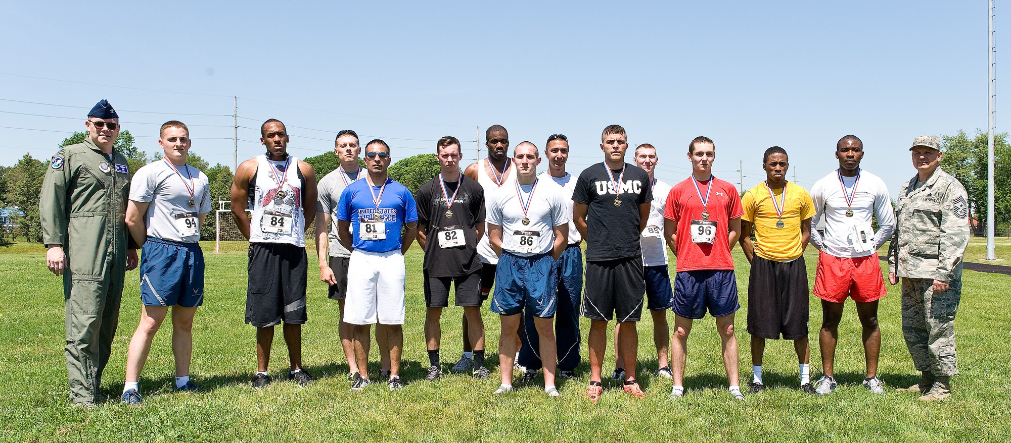 Col. Rick Moore, far left, and Chief Master Sgt. James Smith, far right, commander and command chief of the 436th Airlift Wing, respectively, pose for a photo with runners in the male Fastest Human race May 17, 2013, at Dover Air Force Base, Del. Every runner received medal for their hard work and participation.(U.S. Air Force photo/Roland Balik)