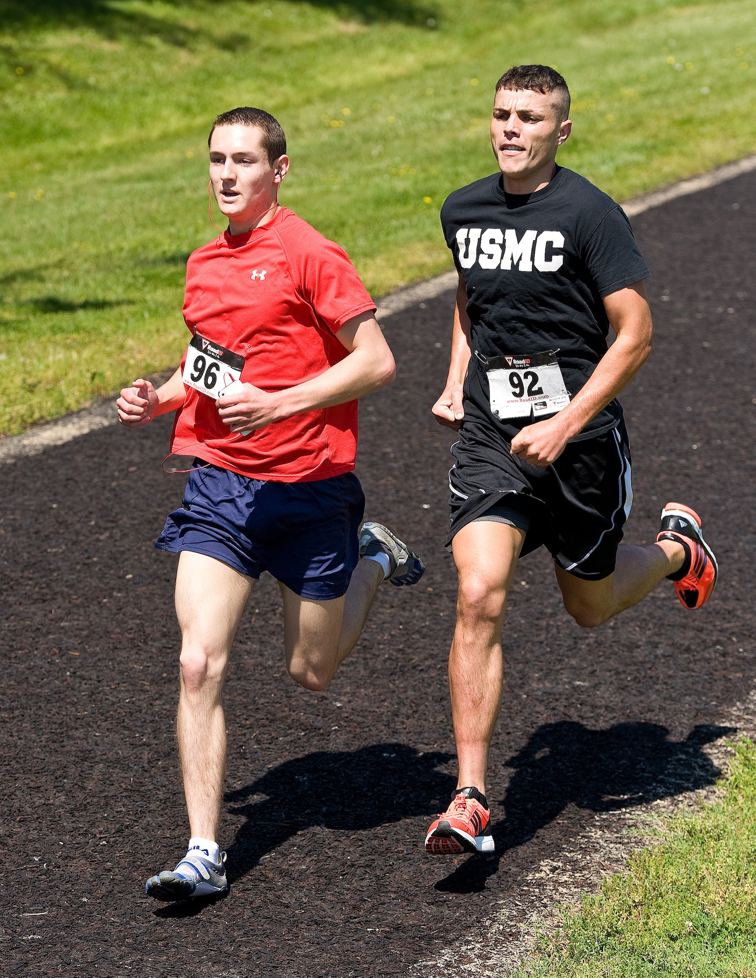 Airman 1st Class Christopher Crezee, left, of the 436th Aerial Port Squadron, passes U.S. Marine Sgt. Jack Sutter, right, of the Joint Personal Effects Depot, on the last lap of the male Fastest Human race May 17, 2013, at Dover Air Force Base, Del.  Crezee passed Sutter with a half-lap left, winning the one-mile race in 4 minutes, 51 seconds. Sutter finished in second place with a time of 4:55. (U.S. Air Force photo/Roland Balik)