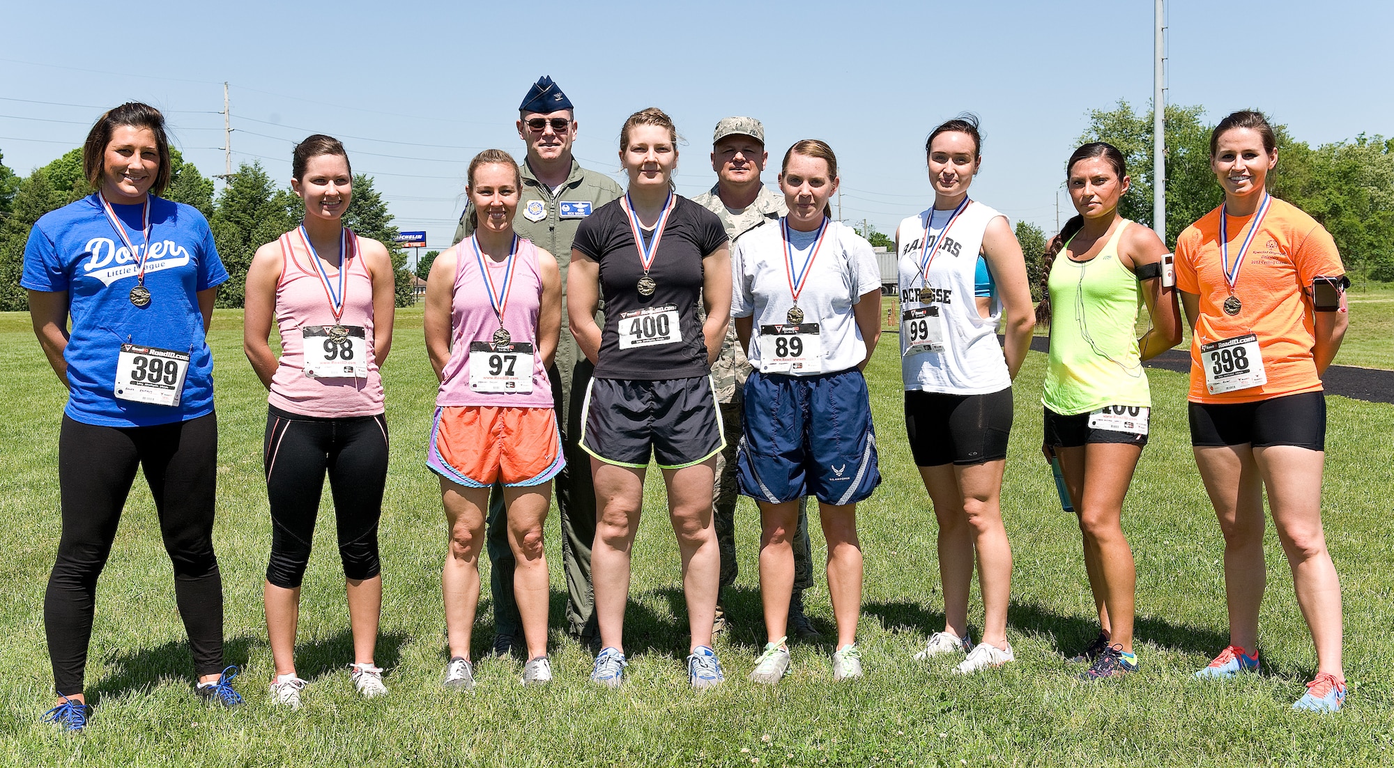 Col. Rick Moore, back row left, and Chief Master Sgt. James Smith, back row right, commander and command chief of the 436th Airlift Wing, respectively, pose for a photo with runners in the female Fastest Human race May 17, 2013, at Dover Air Force Base, Del. Every runner received a medal for their hard work and participation. (U.S. Air Force photo/Roland Balik)