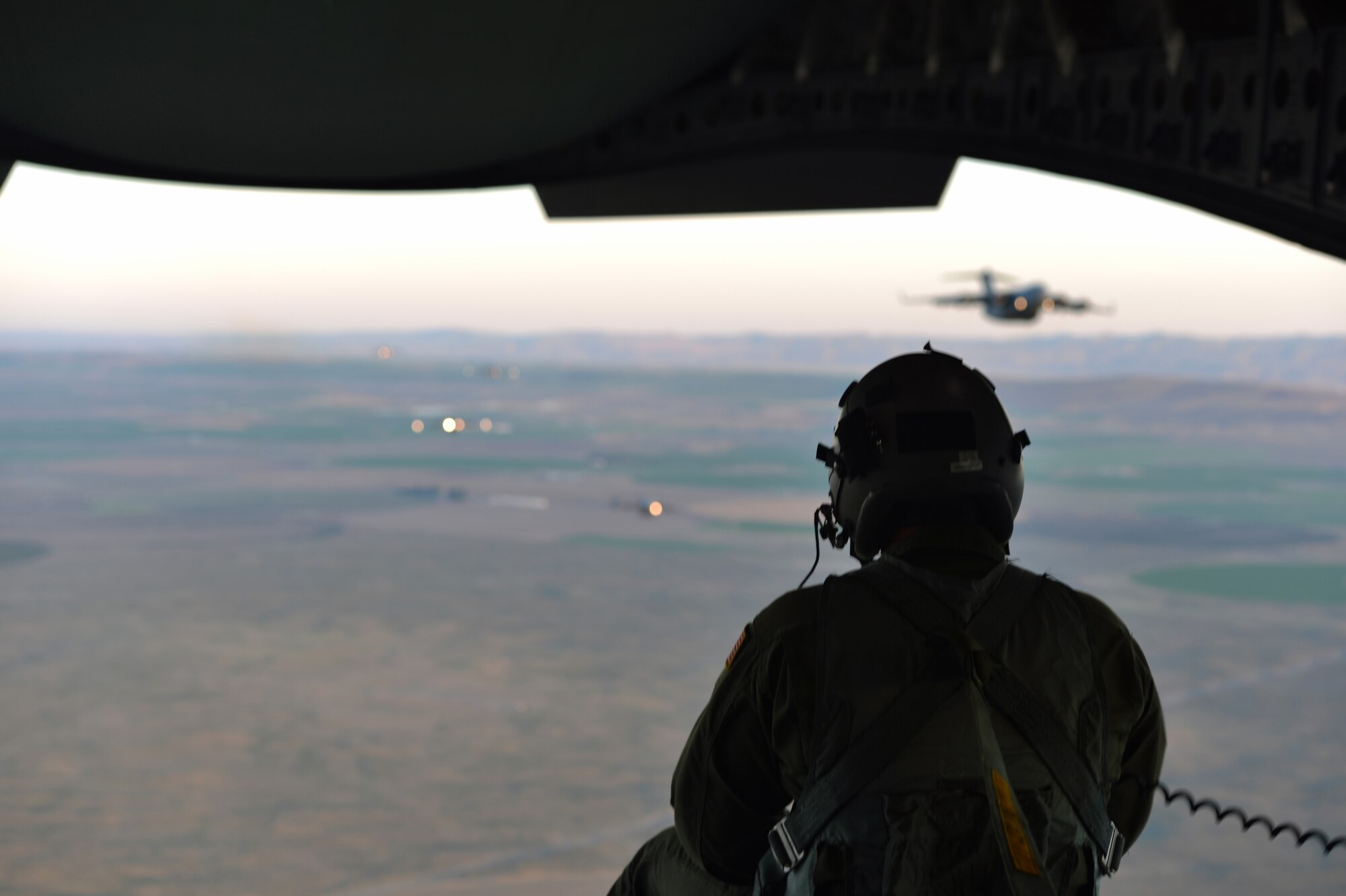 Staff Sgt. Christopher Sicotte, 7th Airlift Squadron loadmaster, watches the sunset May 14, 2013 from the ramp of a C-17 Globemaster III following an airdrop over Moses Lake, Wash. Loadmasters are responsible for ensuring cargo and personnel are properly loaded and situated in the aircraft, monitoring the cargo or personnel throughout the flight and ensuring safe airdrops and personnel jumps. (U.S. Air Force photo/Airman 1st Class Jacob Jimenez)