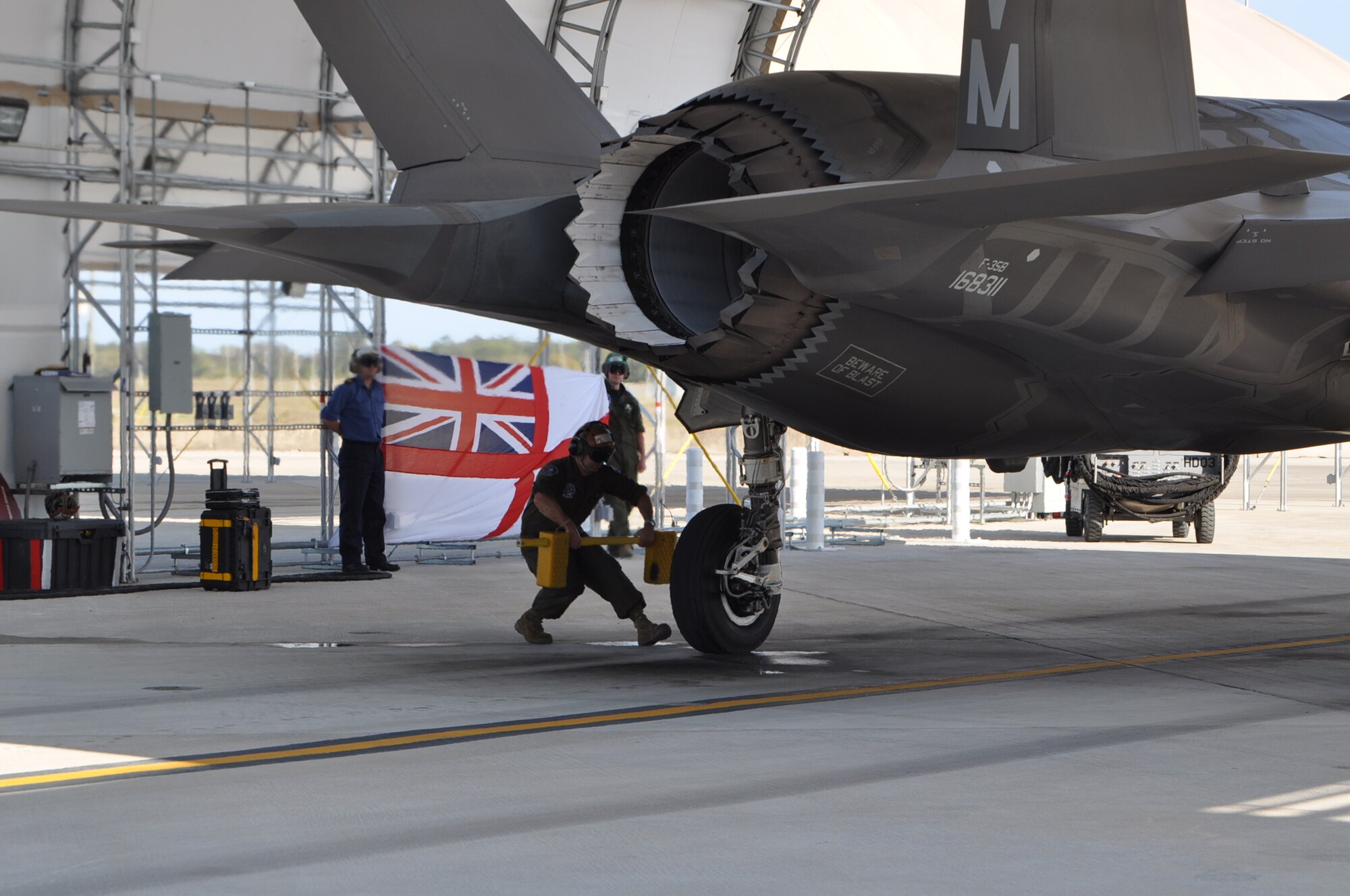 A maintainer places chocks onto the rear wheel of a United Kingdom F-35B Lightning II after a sortie at Eglin Air Force Base, Fla., April 10. UK pilot, Lt. Cmdr. Ian Tidball, became the first Royal Navy student-pilot to fly the sortie. The Eglin Royal Navy F-35B pilots fly with the Marine unit. Tidball has flight experience in the British Sea Harrier and the F-18 Super Hornet. (U.S. Air Force photo/Maj. Karen Roganov)
