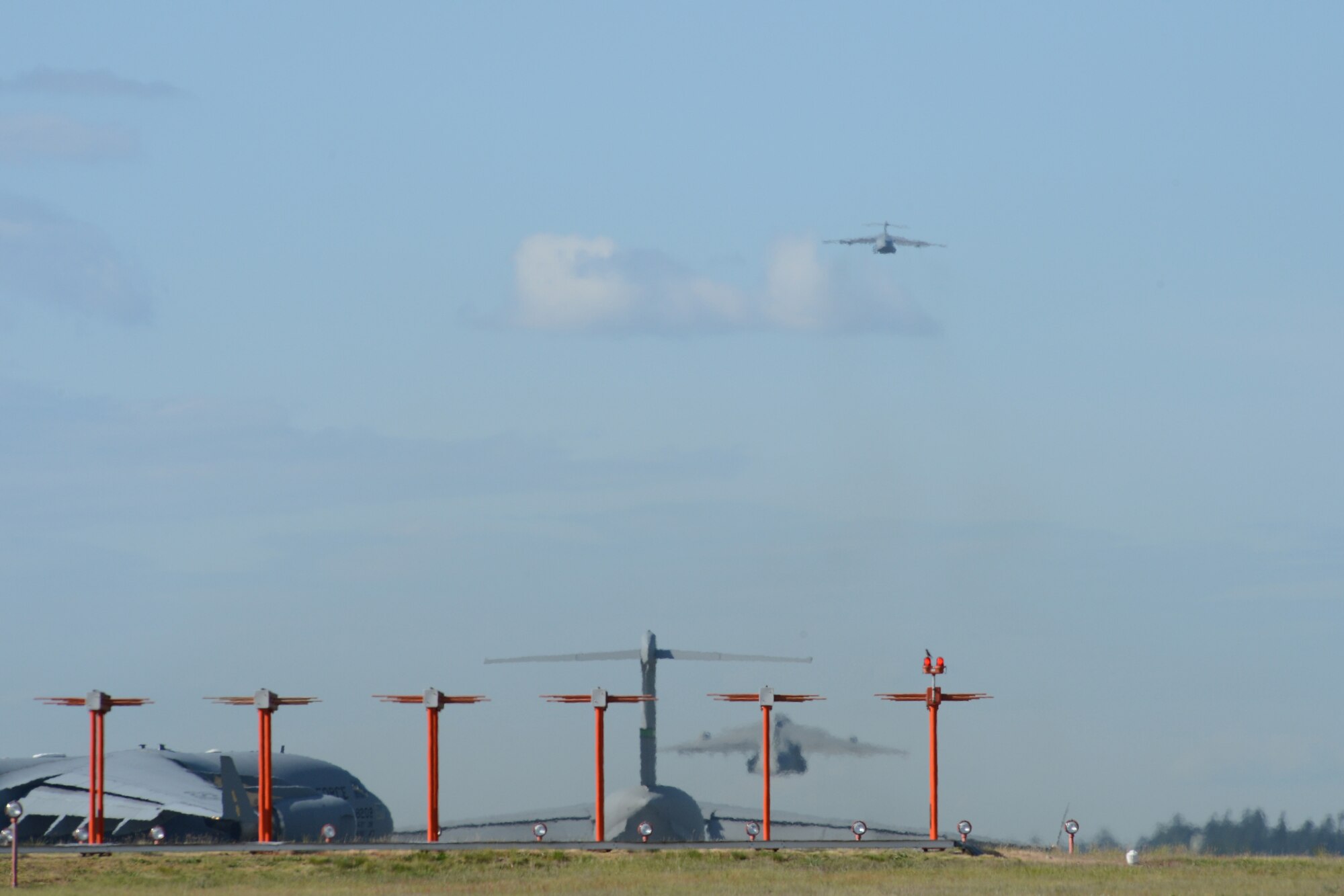 C-17 Globemaster III aircraft takeoff one at a time May 14, 2013 at Joint Base Lewis-McChord, Wash. Airmen from the 7th Airlift Squadron conducted training where they flew seven C-17s in formation, conducted heavy equipment airdrops, low-level operations, midair refueling and landing using night vision goggles. (U.S. Air Force photo/Staff Sgt. Frances Kriss)