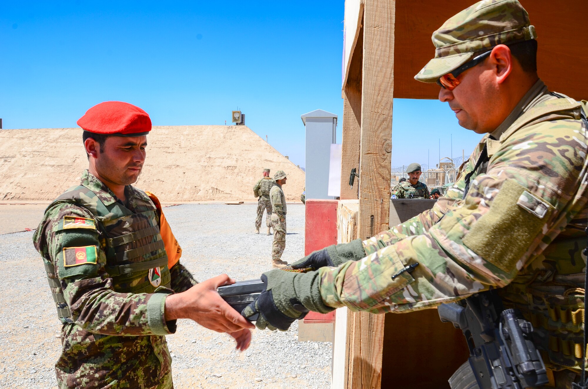 KANDAHAR, Afghanistan – U.S. Air Force Master Sgt. Patrick Flores, 443rd Air Expeditionary Advisor Squadron security forces advisor, distributes ammunition to an Afghan Air Force security forces member prior to a firing range exercise at Kandahar Airfield May 6, 2013. The 443rd Air Expeditionary Advisor Squadron security forces advisors train AAF and Afghan National Army security forces daily as Afghanistan assumes primary responsibility for security in the country. (U.S. Air Force photo/1st Lt Tony Richardson)