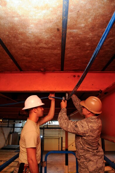 Airmen 1st Class Ryan Darrow and Creston Jenkins Local Area Network cables at the 2nd Logistics Readniess Squadron Shipment and Distribution Flight on Barksdale Air Force Base, La., May 16, 2013. The cables will allow additional computers to be hooked up to Barksdale's network and improve work efficiency. (U.S. Air Force photo/Airman 1st Class Andrew Moua)