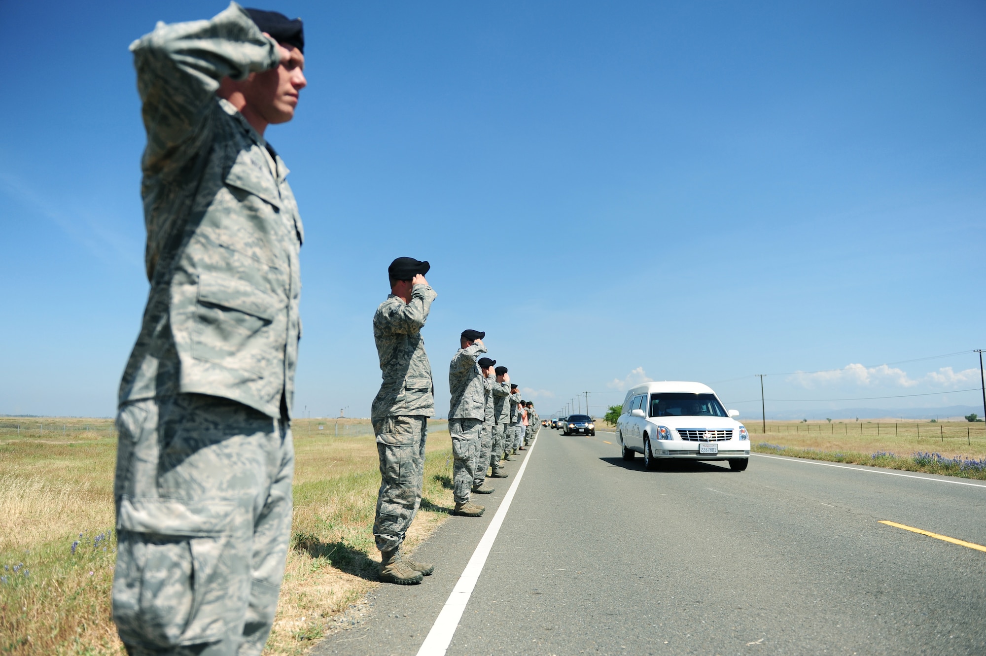 Defenders from the 9th Security Forces Squadron salute the procession of Staff Sgt. Richard Dickson during a dignified transfer at Beale Air Force Base Calif., May 10, 2013. Dickson was killed in a MC-12 Liberty aircraft crash in Afghanistan, April 27. (U.S. Air Force photo by Robert Scott/Released)