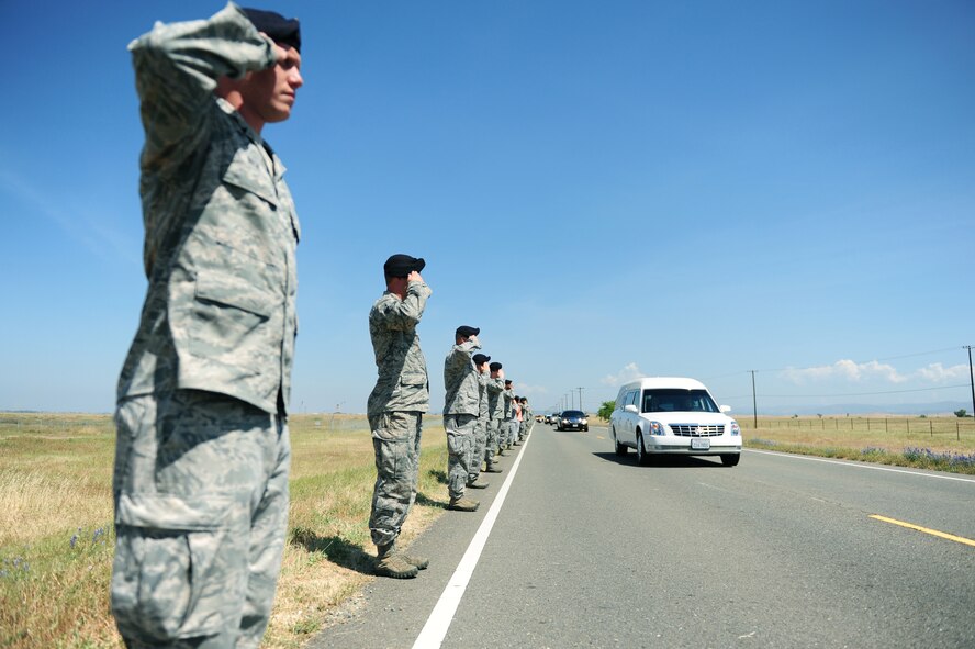 Defenders from the 9th Security Forces Squadron salute the procession of U.S. Air Force Staff Sgt. Richard Dickson during a dignified transfer at Beale Air Force Base, Calif., May 10, 2013. Dickson was killed in a MC-12 Liberty aircraft crash in Afghanistan, April 27. (U.S. Air Force photo by Robert Scott/Released) 
