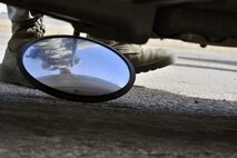 MINOT AIR FORCE BASE, N.D. -- Airman 1st Class Domingo Perez Jr., 5th Security Forces Squadron response force team member, uses a reflective mirror to inspect the undercarriage of a vehicle here, May 13. The primary mission of the 5th SFS is to provide 24-hour law enforcement and security services for the 5th Bomb Wing and all tenant units assigned to the base. (U.S. Air Force photos/Senior Airman Brittany Y. Auld)