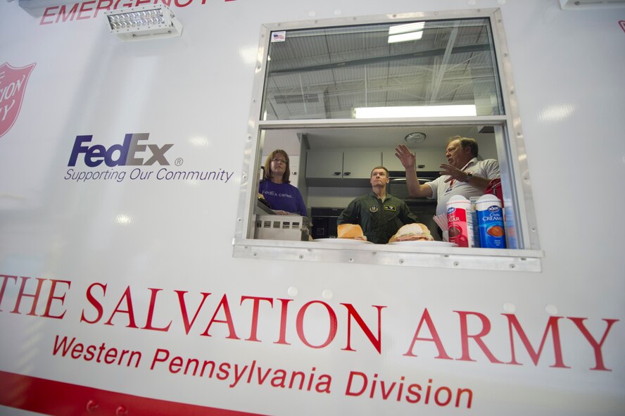 Col. Craig C. Peters is briefed by Reid Scharding, a Salvation Army employee on the capabilities of the Salvation Army’s newest Disaster Response Unit (DRU) at the Pittsburgh International Airport Air Reserve Station, May 15, 2013.  The DRU was donated by FedEx to the Salvation Army during a special ceremony held on base, which also commemorated the 60th National Salvation Army Week. The 911th Airlift Wing was chosen to host the event because of its expertise in disaster response and as a valued community member within the Pittsburgh Airport Area Chamber of Commerce. (Courtesy photo by Jeff Swensen/Getty Images)