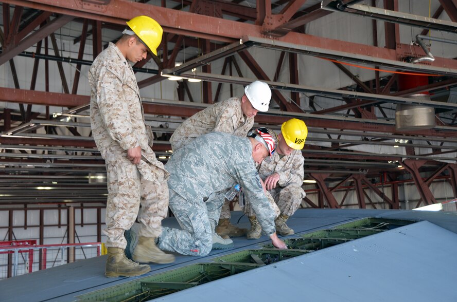 Three Marines with MASS-6, a tenant unit at Westover Air Force Reserve Base, take a closer look at the distinctive T-Tail on the C-5 Galaxy with SMSgt. Patrick Connor, 439th Maintenance Squadron, June 7th, 2013. The C-5 can carry a fully equipped combat-ready military unit to any point in the world on short notice and then provide the supplies required to help sustain the fighting force. (U.S. Air Force photo/SrA. Kelly Galloway)