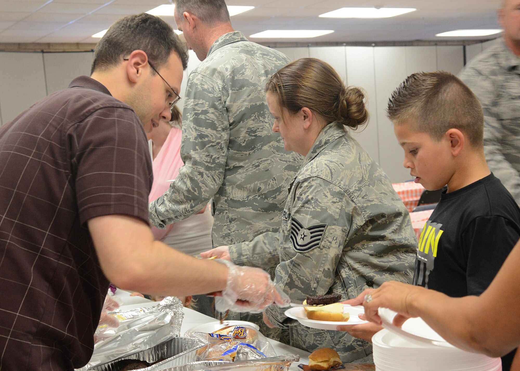 Capt. Aaron Gershbock, 56th Fighter Wing judge advocate, serves food to the attendees during the Deployed Spouses Dinner at the Chapel Annex May 9. Families of service members that are deployed or those members who recently returned from a deployment were treated to dinner, massages, and a coloring area for the children. (U.S. Air Force photo/Airman 1st Class Devante Williams)
