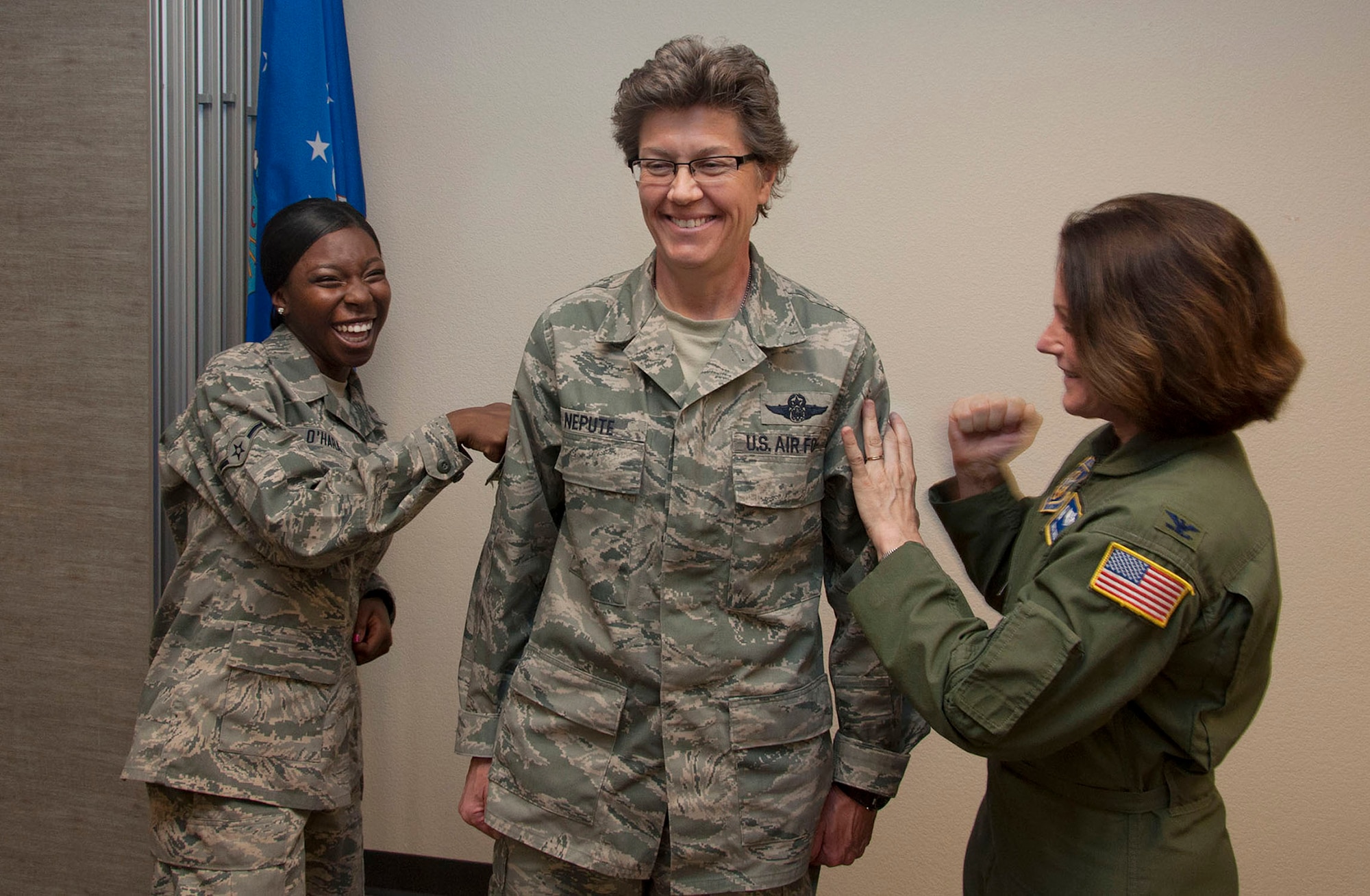 TRAVIS AIR FORCE BASE, Calif. -- Airman Calisha O'Hara (left), the most junior member of the 349th Aeromedical Evacuation Squadron, and Col. Nancy Mikulin (right), 349 AES commander, symbolically "pin on" Chief Master Sgt. Laura Nepute's new rank insignia.  Nepute was promoted in a ceremony at Travis Air Force Base, Calif., May 5, 2013 attended by members of the 349th Aeromedical Evacuation Squadron and well wishers. (U.S. Air Force photo / Lt. Col. Robert Couse-Baker)