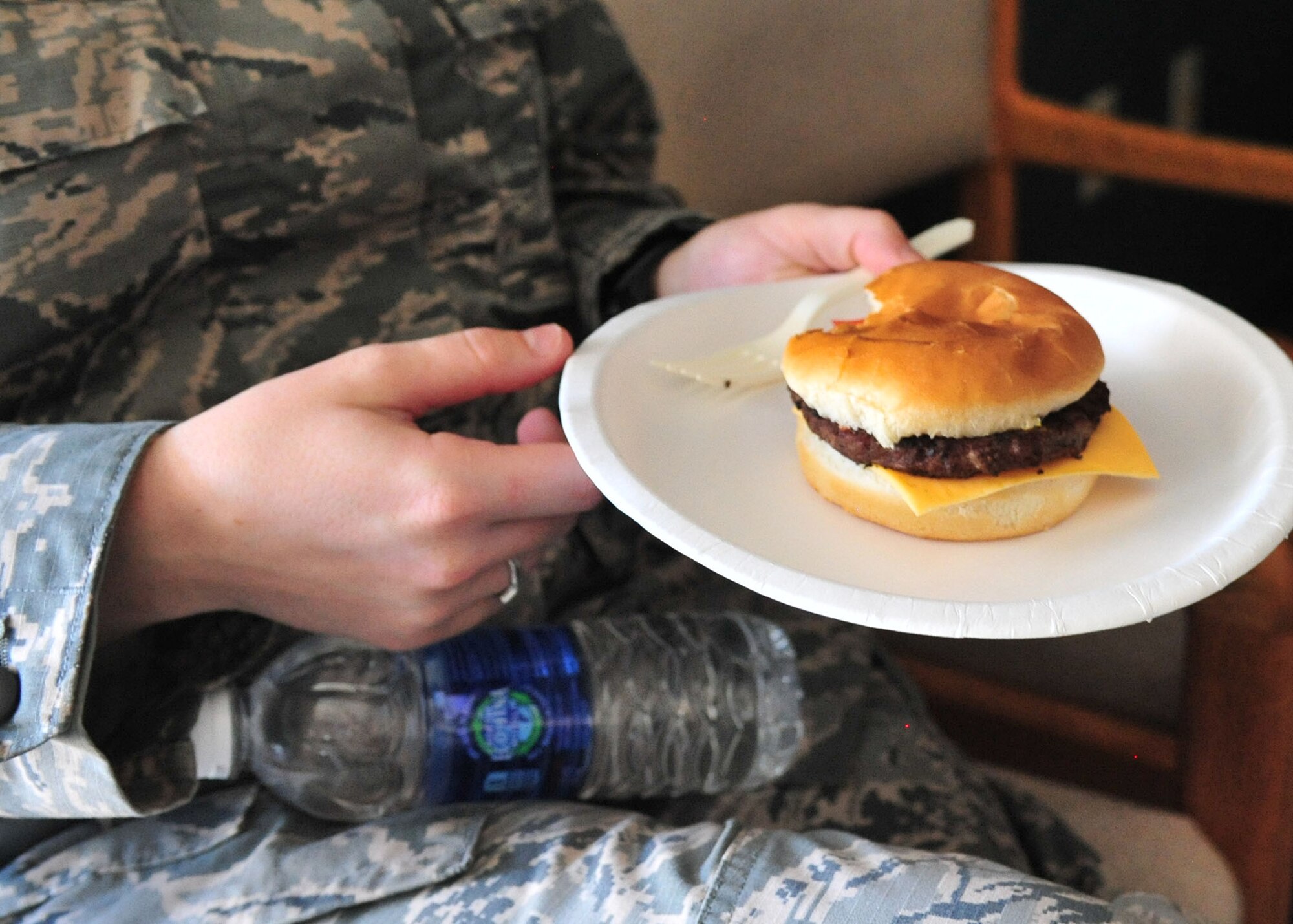 A U.S. Air Force security forces troop enjoys a burger in the fire department at Cannon Air Force Base, N.M., May 14, 2013. Members of the 27th Special Operations Civil Engineer Squadron set aside their gear and demonstrated culinary techniques as they barbequed for members of the 27th Special Operations Security Forces Squadron in honor of National Police Week. (U.S. Air Force photo/Senior Airman Alexxis Pons Abascal) 