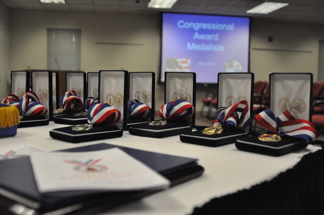 Congressional Award medals on a table prior to the Congressional Awards Program at the Bellevue Welcome Center in Bellevue, Neb., on May 13. Rep. Jeff Fortenberry gave each award to young adults who had served a cumulative number of hours in volunteer public service, personal development, physical fitness and an expedition or exploration trip. (U.S. Air Force photo by Senior Airman Peter R.O. Danielson/Released)