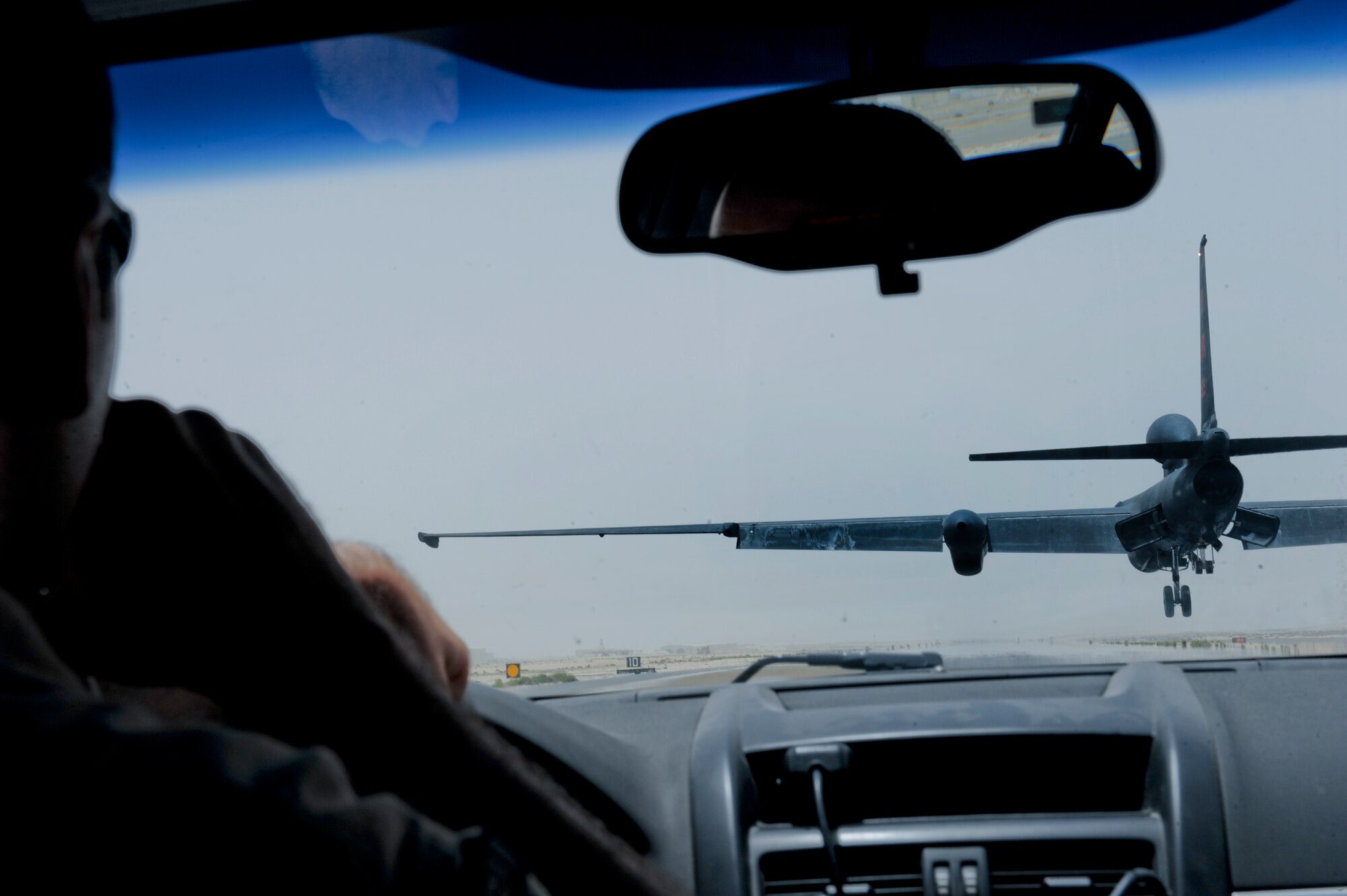 U.S. Air Force Maj. Greg McKenzie, 99th Expeditionary Reconnaissance Squadron U-2 pilot, directs U.S. Air Force Maj. Patrick Hudson, 99th Expeditionary Reconnaissance Squadron U-2 pilot, via radio on how close he is to the ground during the landing of Hudson’s final combat sortie, May 17, 2013, at an undisclosed location in Southwest Asia. Due to the limited visibility and associated challenges while flying in a full pressure suit, a mobile pilot is used to ensure that the aircraft is landed safely. McKenzie hails from Merced, Calif., and Hudson is native to Fayette, Miss., both are deployed from Beale Air Force Base, Calif. (U.S. Air Force photo by Staff Sgt. Joshua J. Garcia)