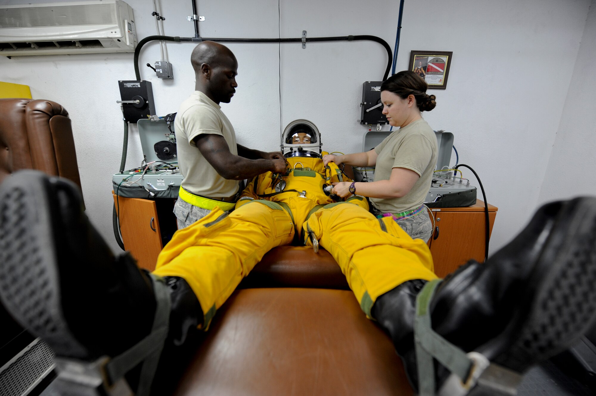 U.S. Air Force Staff Sgt. Joshua Thornton, 99th Expeditionary Reconnaissance Squadron life support technician, and U.S. Air Force Staff Sgt. Heather Doyle, 99th ERS aerospace physiology technician, secure the torso portion of the flight suit for U.S. Air Force Maj. Patrick Hudson, 99th Expeditionary Reconnaissance Squadron U-2 pilot, prior to his final combat sortie, May 17, 2013, at an undisclosed location in Southwest Asia. The torso portion of the suit acts as a flotation device and connects Hudson to the ejection seat. Hudson hails from Fayette, Mi., and is deployed from Beale Air Force Base, Calif. Thornton is native to Minden, La., and is also deployed from Beale AFB, along with Doyle. (U.S. Air Force photo by Staff Sgt. Joshua J. Garcia)