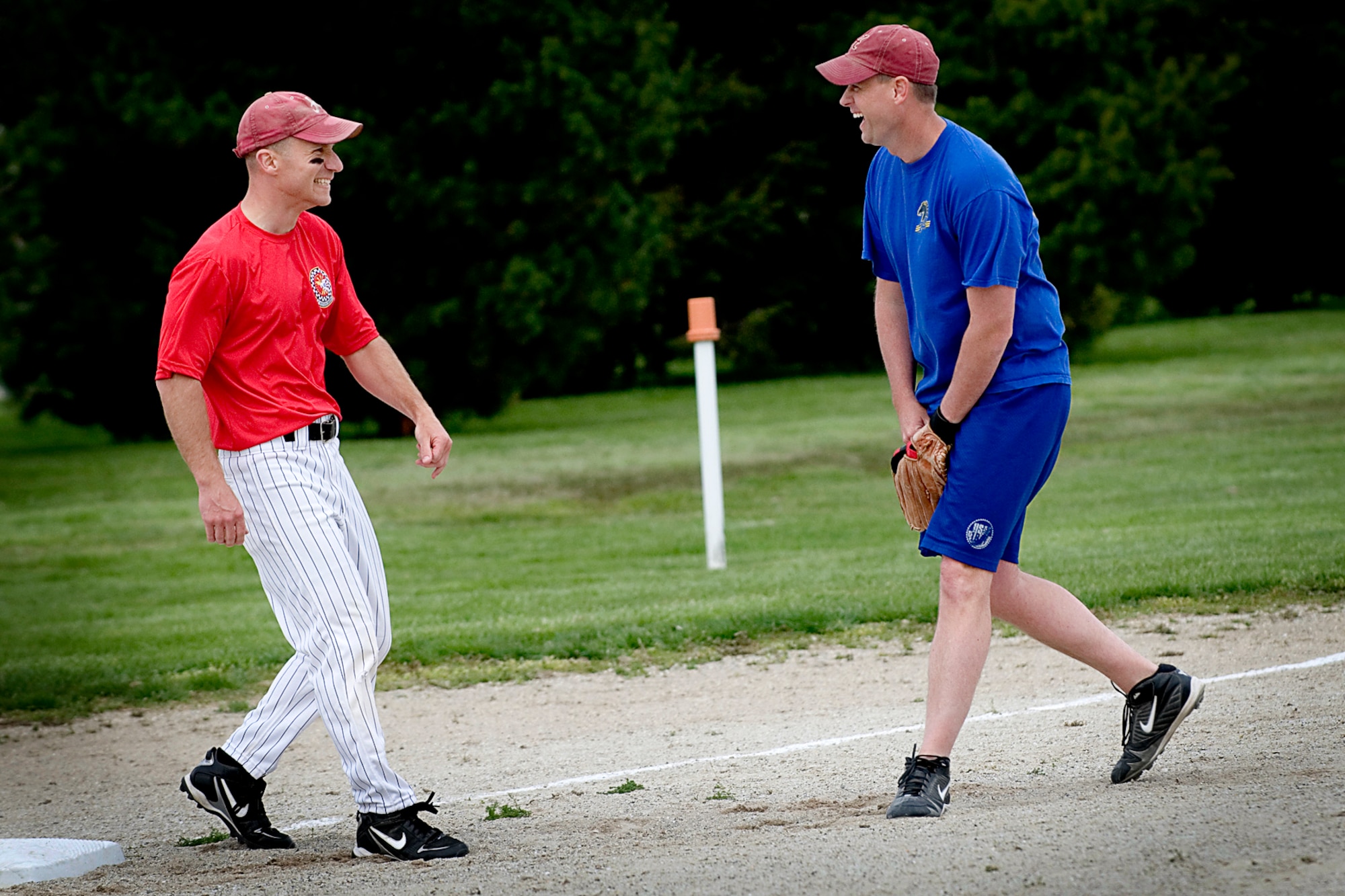 GRISSOM AIR RESERVE BASE, Ind. -- Dan Keeney, left, 74th Air Refueling Squadron Fightin' Red Tags outfielder, jokes with Chad Tice, 72nd Air Refueling Squadron Dark Side third baseman, after making it safety to the bag. The 74th ARS defeated their counterpart 72nd ARS rivals 9-5 April 27 to claim the 7th Annual Jovanovich Cup. (U.S. Air Force photo/Tech. Sgt. Doug Hays)
