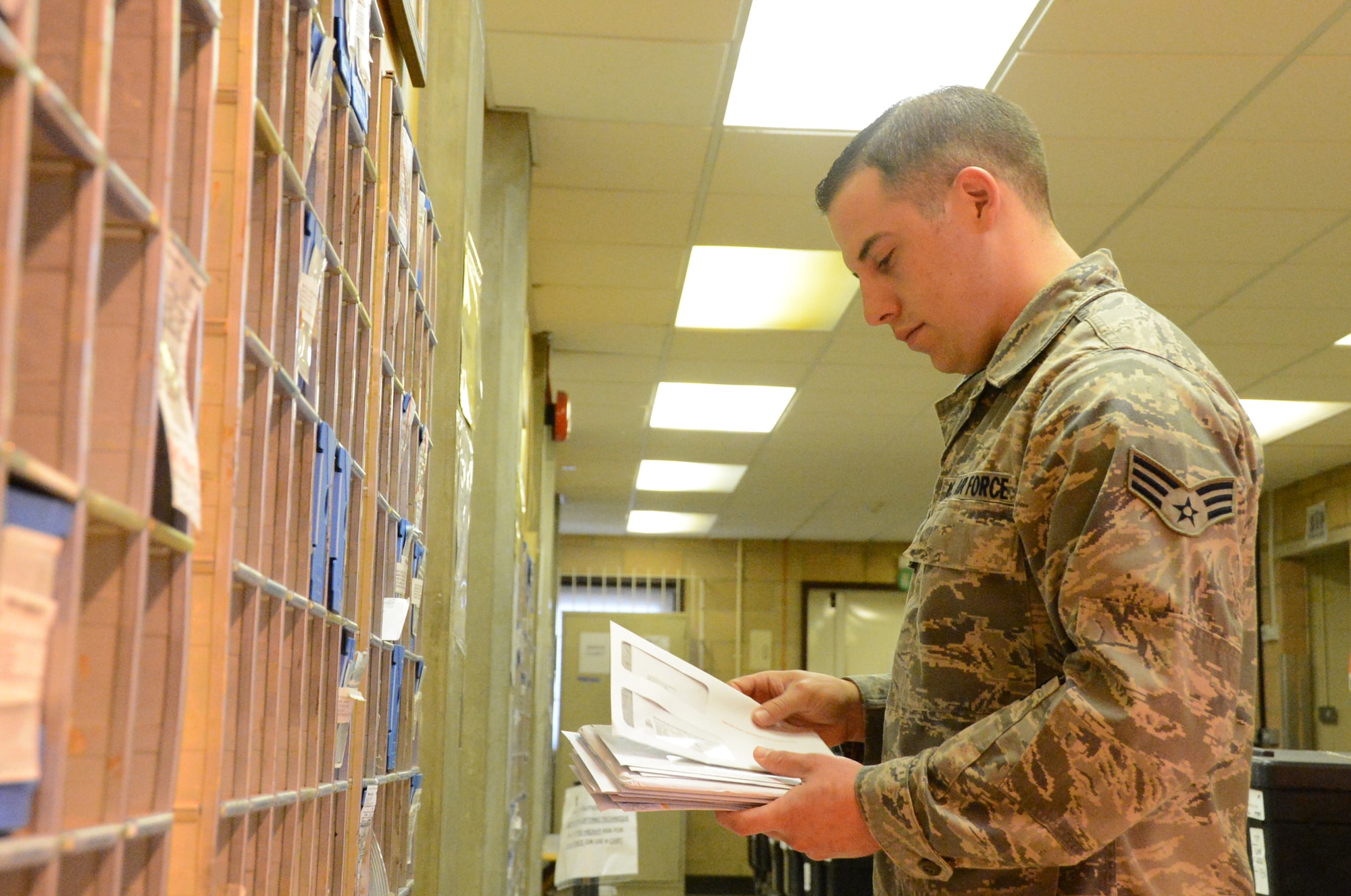 ROYAL AIR FORCE LAKENHEATH, England -- Senior Airman Jeremiah Salyers, 48th Communications Squadron postal clerk, sorts through a stack of mail to deliver each letter to its designated box at the RAF Lakenheath Post Office May 15, 2013. The newly implemented Optical Character Reader helps Airmen deliver mail more efficiently. (U.S. Air Force photo by Airman 1st Class Trevor T. McBride) 