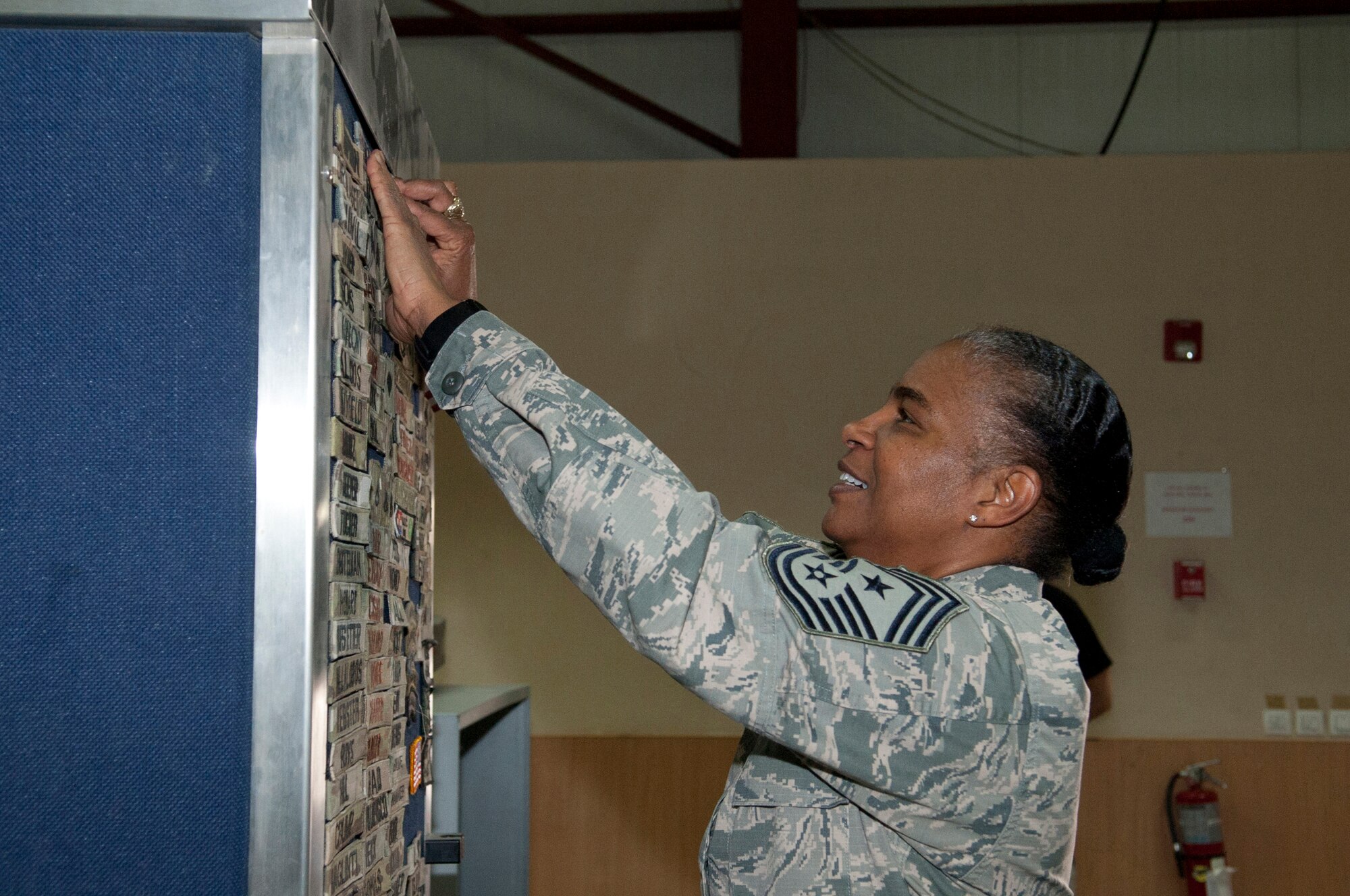 Chief Master Sgt. Shelina Frey adds a name tag to the passenger terminal's “Wall of Fame” at Transit Center at Manas, Kyrgyzstan, May 14, 2013. Frey toured the Transit Center as the new U.S. Air Forces Central Command command chief. (U.S. Air Force photo/Staff Sgt. Robert Barnett)