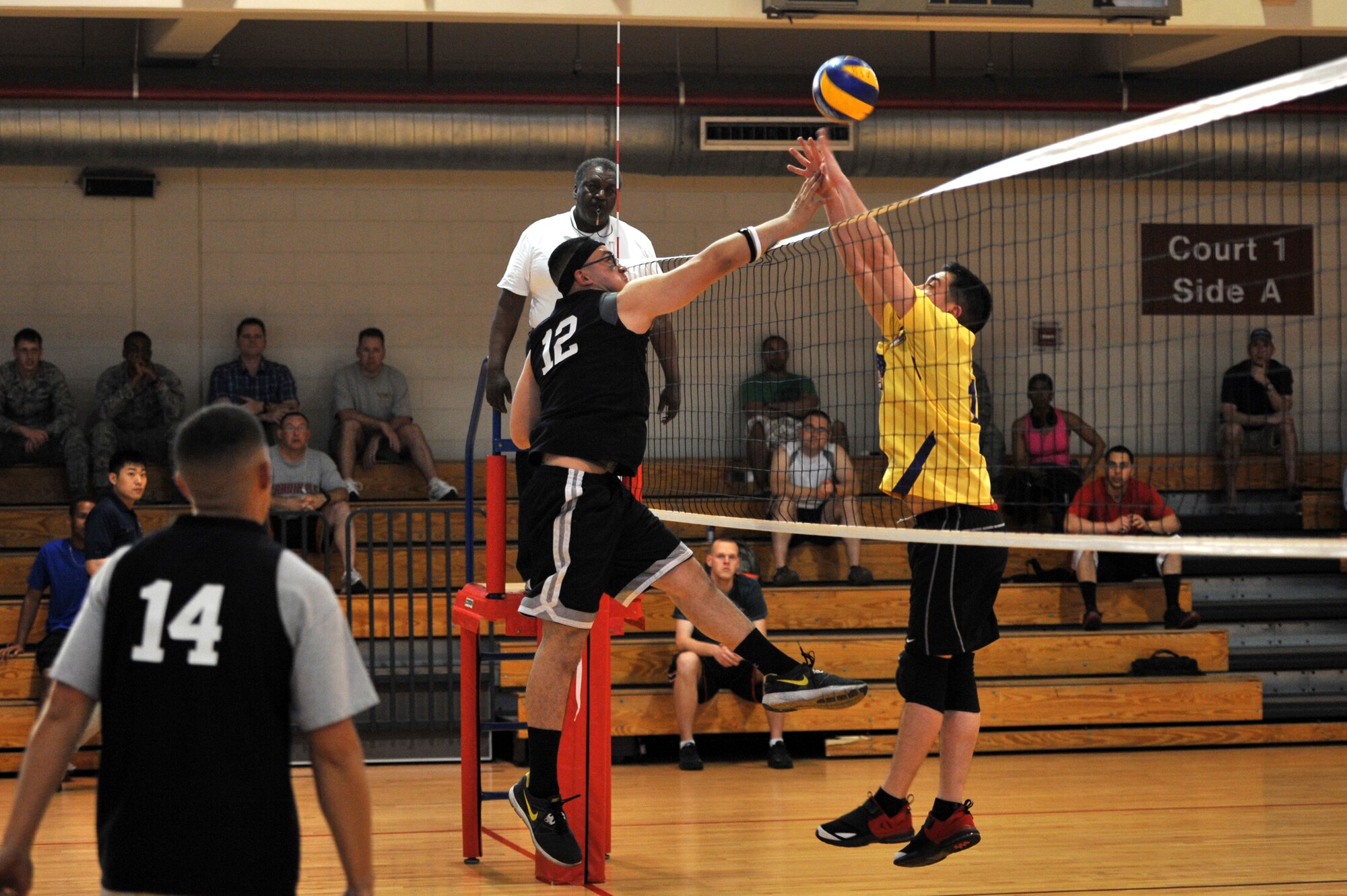 Airman 1st Class Peter Mossuto, 51st Maintenance Squadron aircraft structural maintenance apprentice, spikes the ball through the arms of Staff Sgt. Shawn Erway, 51st Communication Squadron video systems technician, during the intramural volleyball championship at Osan Air Base, Republic of Korea, May 15, 2013. The two teams faced off in a best-of-five-games series to determine who would take home the championship trophy. (U.S. Air Force photo/Staff Sgt. Emerson Nuñez)