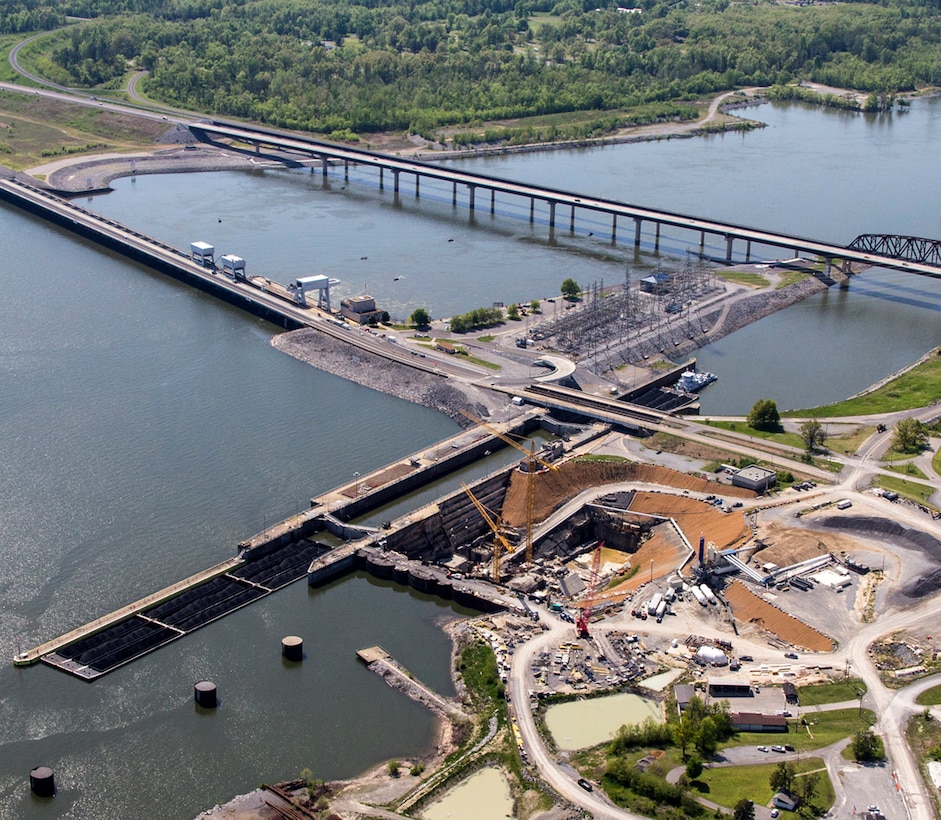 This aerial photo of the Kentucky Lock Addition project taken April 26, 2013 in Grand Rivers, Ky., shows construction of a new 1200-foot lock landward of the existing 600-foot lock and the relocated highway and railroad bridges downstream of the dam. The upstream-bound split barge tow will be able to lock through as a single tow when the new lock is completed by the U.S. Army Corps of Engineers Nashville District in partnership with the Tennessee Valley Authority.