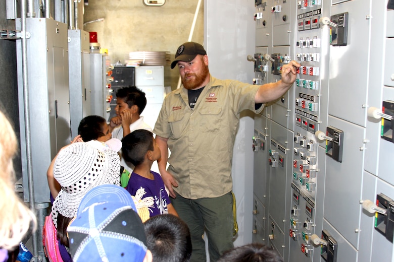 More than 80 second grade students from Cortez Elementary, a math and science magnet school in Pomona, Calif., took a field trip to Prado Dam May 16.  The tour included a nearly two-mile trek through the flood control basin up to the dam's 627-foot control tower.  William Kramer, a dam operator with the district assigned to Prado Dam, shows students the gate controls during a portion of the field trip.