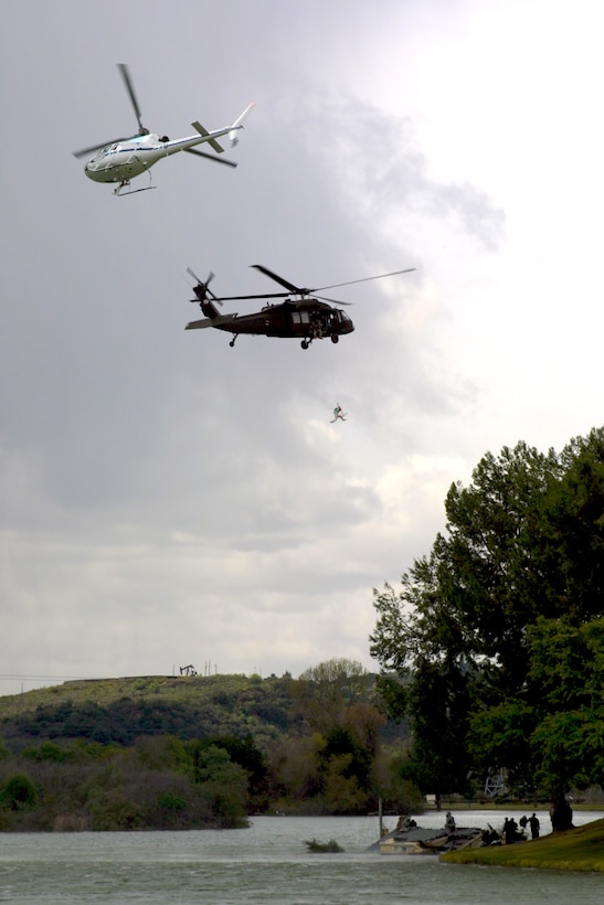 An Army National Guard Blackhawk helicopter executes a simulated rooftop evacuation on the set of a new recruitment commercial filmed at Whittier Narrows Park near Los Angeles.  The National Guard and the commercial's director, Zach Snyder, worked with the Los Angeles District to obtain filming permits for the shoot. (USACE photo by David A. Salazar)