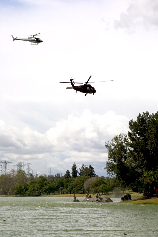 A civilian helicopter transporting a film crew circles above an Army Blackhawk helicopter as it executes a simulated rooftop evacuation on the set of the Army National Guard's new recruiting commercial.  The National Guard worked with the Los Angeles District to secure a filming permit for the shoot, which took place at Whittier Narrows Park March 8.